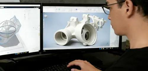 Engineer reviewing CAD model on dual monitors