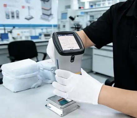 Technician scanning a metal part with a handheld measuring device on a workbench