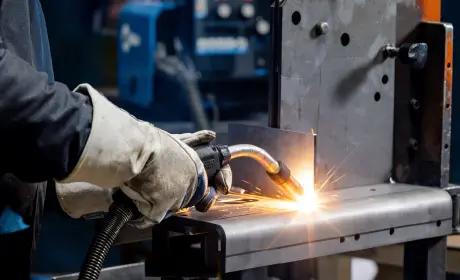 MIG welding torch on thick steel with bright weld arc