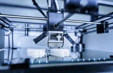 FDM printer nozzle extruding filament onto build plate